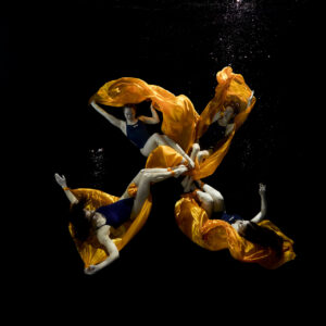 Unterwasser Fotoshooting mit fließendem orangefarbenem Stoff und eleganter Pose